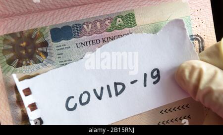 Coronavirus Konzept. Beachten Sie das COVID-19-Coronavirus und das Visum für Großbritannien im Reisepass. Grenzkontrolle und Quarantäne von mit Coronavirus infizierten Touristen. Roman cor Stockfoto