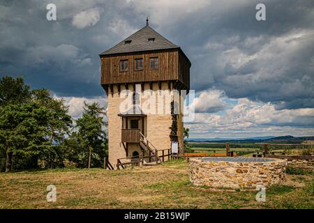Hartenstejn, Tschechien - 11. August 2018: Aussichtsturm als Teil der zerstörten gotischen Burg aus dem 15. Jahrhundert und Steinwasserbrunnen. Stockfoto