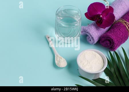 Kollagenpulver in halber Kokosnuss mit einem Löffel zur Messung der Menge. Zusätzliche Proteinaufnahme. Stockfoto