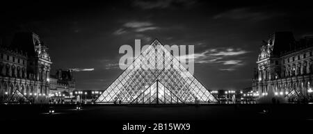 Paris - 25. September 2013: Louvre in der Nacht in Paris. Der berühmte Louvre ist eines der beliebtesten Reiseziele in Frankreich. Panoramablick auf die beleuchtete Louvr Stockfoto