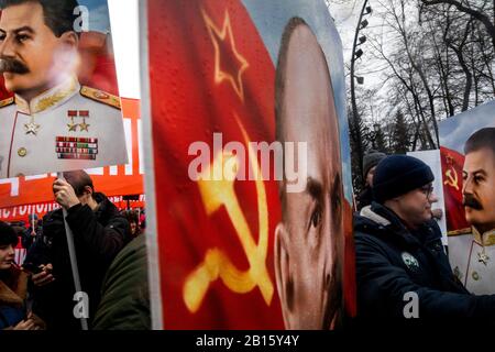 Moskau, Russland. Februar 2020 Teilnehmer einer Kundgebung und eines marsches in Zentral-Moskau anlässlich des 102. Jahrestages der Gründung der sowjetischen Roten Armee und der sowjetischen Marine. Die Leute halten Banner mit dem Porträt der sowjetischen russischen Führer Josef Stalin und Wladimir Lenin Stockfoto