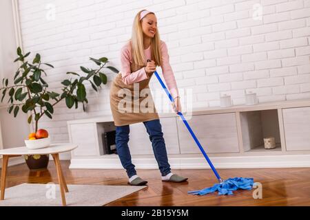 Schöne Hausfrau putzt gern ihr Zuhause. Stockfoto