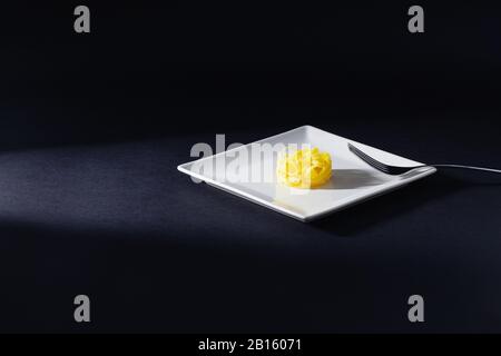 Edelstahlgabel und Tagliatelle Pasta auf dem weißen Teller. Diät-Mittagessen. Stockfoto