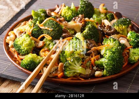 Vegetarisch rühren Sie in einer Platte auf dem Tisch schiitake Pilze, Brokkoli, Karotten und Cashewnüsse in die enge. Horizontal Stockfoto