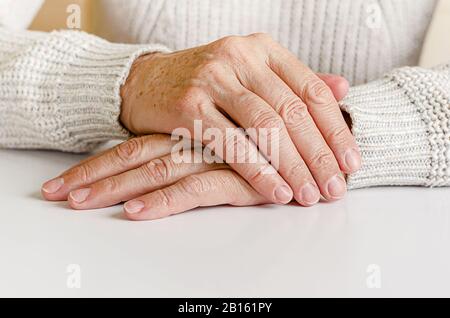 Hahds einer älteren Frau auf weißem Hintergrund. Nahaufnahme, Kopierbereich. Stockfoto