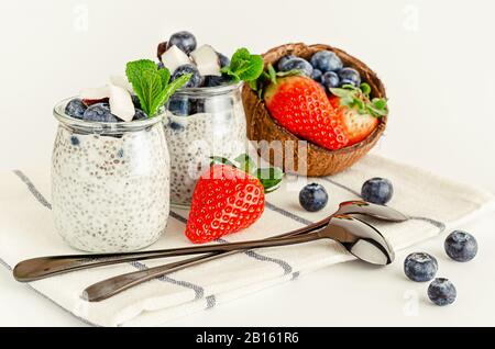 Hausgemachter chia Seed Pudding mit Beeren, Kokosnuss und Minze. Gesundes Essen und Superfoods Konzept. Stockfoto