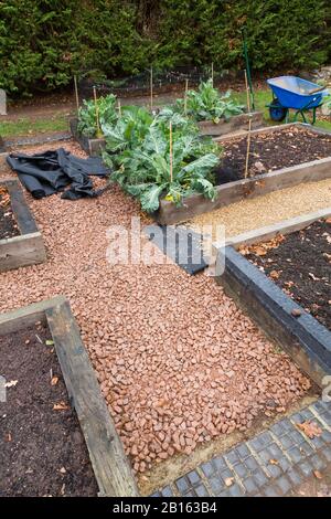 Installation von Unkrautkontrollmembran oder Stoff- und Schotterweg in einem Garten in England, Großbritannien Stockfoto