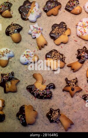 Köstliche frisch gebackene Plätzchen in verschiedenen Formen mit Schokolade und bunten Krümeln in der weihnachtszeit. Stockfoto