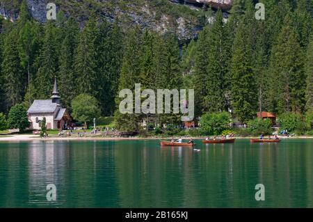 Touristen, Boote und Kirche der Jungfrau Maria am Pragser Wildsee, Naturpark Fanes-Sennes-Prags, Trentino-Südtirol, Italien Stockfoto