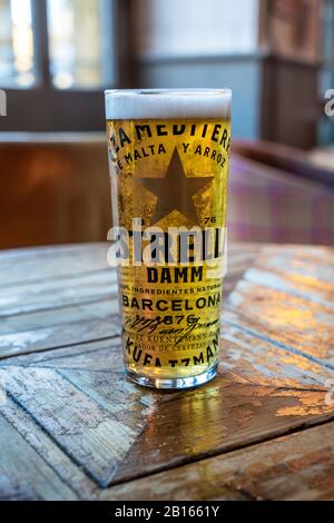 Pint Glas Estrella Lagerbier auf einem von hinten beleuchteten Tisch Stockfoto