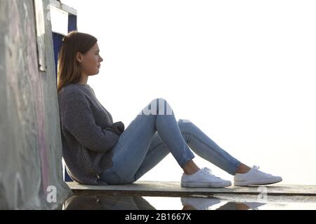 Seitenansicht Porträt eines pensiven Teenagers, das draußen sitzt Stockfoto