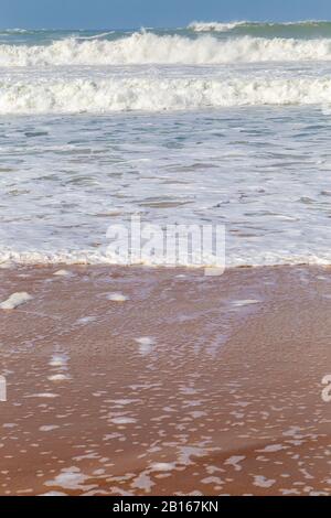 Meeresküste, Bewegungswellen mit Schaum. Windkraft. Türkisfarbenes Wasser. Stockfoto