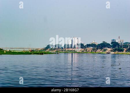 Ein Fluss ist ein natürlich fließender Wasserlauf, in der Regel Süßwasser, der in Richtung eines Ozeans, Meeres, Sees oder eines anderen Flusses in Dhaka fließt. Stockfoto