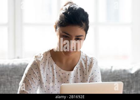 Indianische Ethnicity Woman, die Online-Einkäufe mit einem Laptop macht Stockfoto