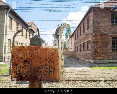 Stacheldraht- und Backsteinbarackengebäude des Konzentrationslagers Auschwitz Stockfoto