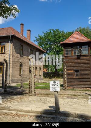 Warnschild des Konzentrationslagers Auschwitz bei einem Wachturm Stockfoto