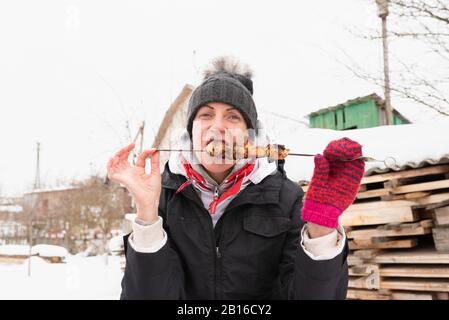 Eine Frau mit einer Schashlik auf einem Shampoo, im Winter. Stockfoto