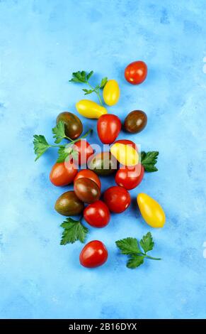 Kreatives Layout aus frischen Tomaten und frischem Basilikum. Lebensmittelkonzept. Gemüse isoliert auf blauem Grund. Stockfoto