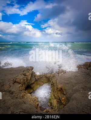 Die Wellen schlagen gegen die Felsen an den einzigartigen und erstaunlichen Blowing Rocks Preserve in Jupiter, FL. Stockfoto