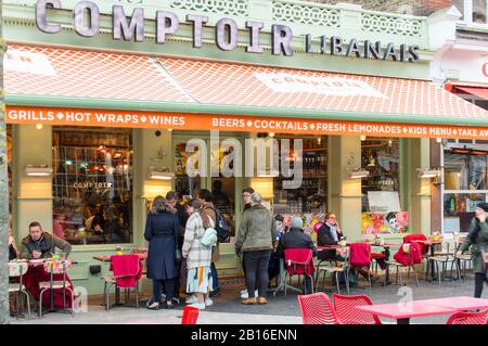 Touristen sitzen im Sitzbereich des Außenrestaurants Stockfoto