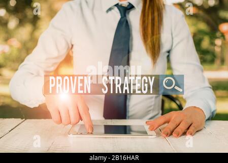 Schreiben Sie einen Hinweis mit Einer Bewährten Strategie. Geschäftskonzept für Bestätigten Ansatz oder Praktiken bei der Generierung von Verkäufen oder führt weibliche Geschäftsperson sitzend Stockfoto