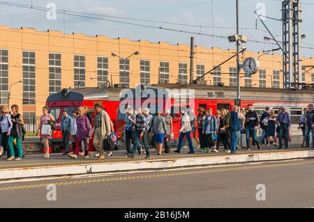 Sankt Petersburg, Russland 08.30.2019: Die Fahrgäste gehen nach Ankunft eines S-Bahn-Vororts am Bahnsteig des Baltischen Bahnhofs entlang. Stockfoto