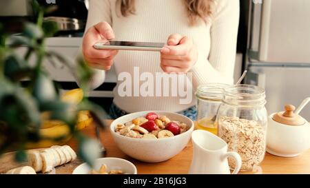 Blogger Mädchen Lebensmittelfotografie des Frühstücks in der Küche. Sonniger, fauler morgendlicher Lebensstil Stockfoto