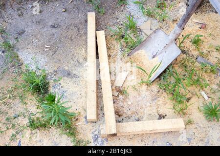 Holzstäbe am Boden mit einer Schaufel Stockfoto