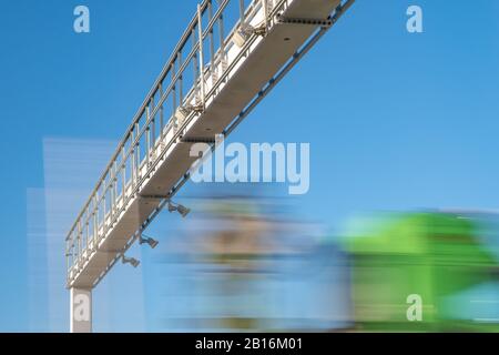 LKW fährt durch die Autobahn durch die Mautstelle, Mautgebühren, verschwommene Bewegung im Bild Stockfoto