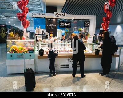 Athen, Griechenland - Februar, 11. 2020: Menschen, die im Kayak Pure Magic greek Frozen Yoghurt und Eiscafé Shop im Hauptterminal von Athen bestellen Stockfoto