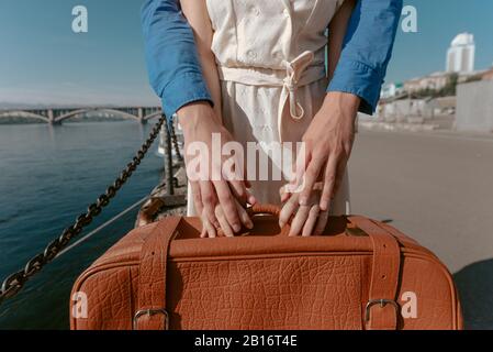 Junges Paar hält Vintage-Koffer draußen Stockfoto