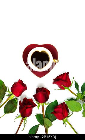 Rote Rosen kreative Komposition flaches Lay-Layout mit Kaffee in herzförmiger Tasse und Untertasse auf weißem Hintergrund, mit negativem Kopierraum. Stockfoto