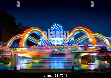 Verschwommene farbige Lichtlinien von der sich schnell bewegenden Fairground Attraktion auf der Sassenheimer Stadtmesse in den Niederlanden. Stockfoto