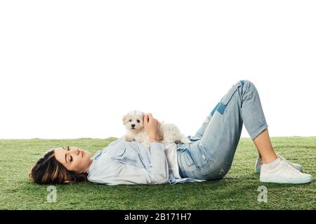 Frau mit Havanese Welpe auf Gras liegend isoliert auf Weiß Stockfoto