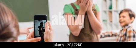 Panoramaaufnahme des Schulmädchens mit Foto von Mitschüler, Cybermobbing Konzept Stockfoto