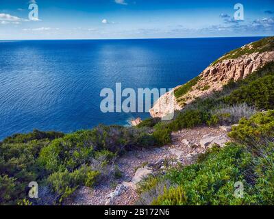 Blick auf das tiefblaue Meer und die üppige mediterrane Vegetation in Sardegna, einem schönen Wildnisgebiet über dem Meer Stockfoto