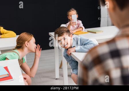 Selektive Fokussierung von Schulkindern beim Fotografieren von Klassenkameraden mit schwarzem, Cyberbullying Konzept Stockfoto