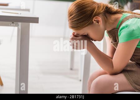 Frustrierte und schikanierte Schulmädchen, die im Klassenzimmer sitzen Stockfoto