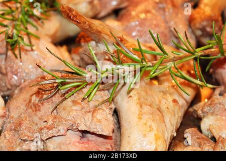 Nahaufnahme von Rosmarin über aufgeschnittenen Entenstücken Stockfoto