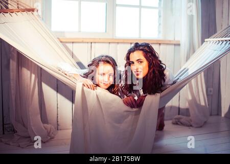 Junge hübsche Schwestern zu Hause am frühen Morgen in der Hängematte, Lifestyle casual Personen Konzept Stockfoto