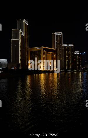 Hotel- und Wohnkomplex am Fluss Haihe nachts in Tianjin, China Stockfoto