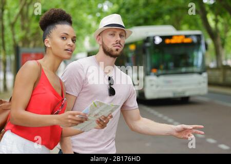 Junge Paare im Urlaub, die einen Bus beeilen Stockfoto