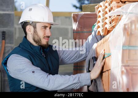 Arbeiter baut eine Ziegelmauer im Stockfoto