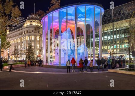 Budapest, Ungarn - 30. November 2019: Statue des ungarischen Dichters Mihaly Vorosmarty am Vorosmarty-Platz Weihnachtsmarkt am Abend. Stockfoto