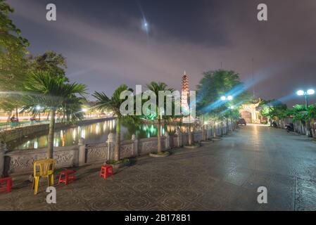 Fassadeneingang des buddhistischen Tempels Tran Quoc Reflexion am Westsee in Hanoi in der Nacht Stockfoto