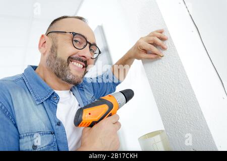 Man bohren die Wand mit Bohrer perforator Stockfoto