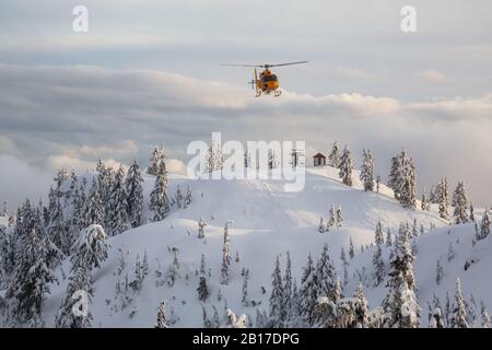 North Vancouver, British Columbia, Kanada - 17. Februar 2020: Der Hubschrauber zur Suche und Rettung von Nordufern fliegt, um einem Skifahrer im Hintercountr zu helfen Stockfoto