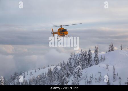 North Vancouver, British Columbia, Kanada - 17. Februar 2020: Der Hubschrauber zur Suche und Rettung von Nordufern fliegt, um einem Skifahrer im Hintercountr zu helfen Stockfoto