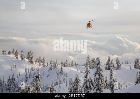 North Vancouver, British Columbia, Kanada - 17. Februar 2020: Der Hubschrauber zur Suche und Rettung von Nordufern fliegt, um einem Skifahrer im Hintercountr zu helfen Stockfoto