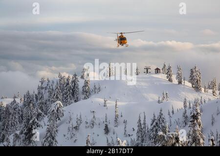 North Vancouver, British Columbia, Kanada - 17. Februar 2020: Der Hubschrauber zur Suche und Rettung von Nordufern fliegt, um einem Skifahrer im Hintercountr zu helfen Stockfoto